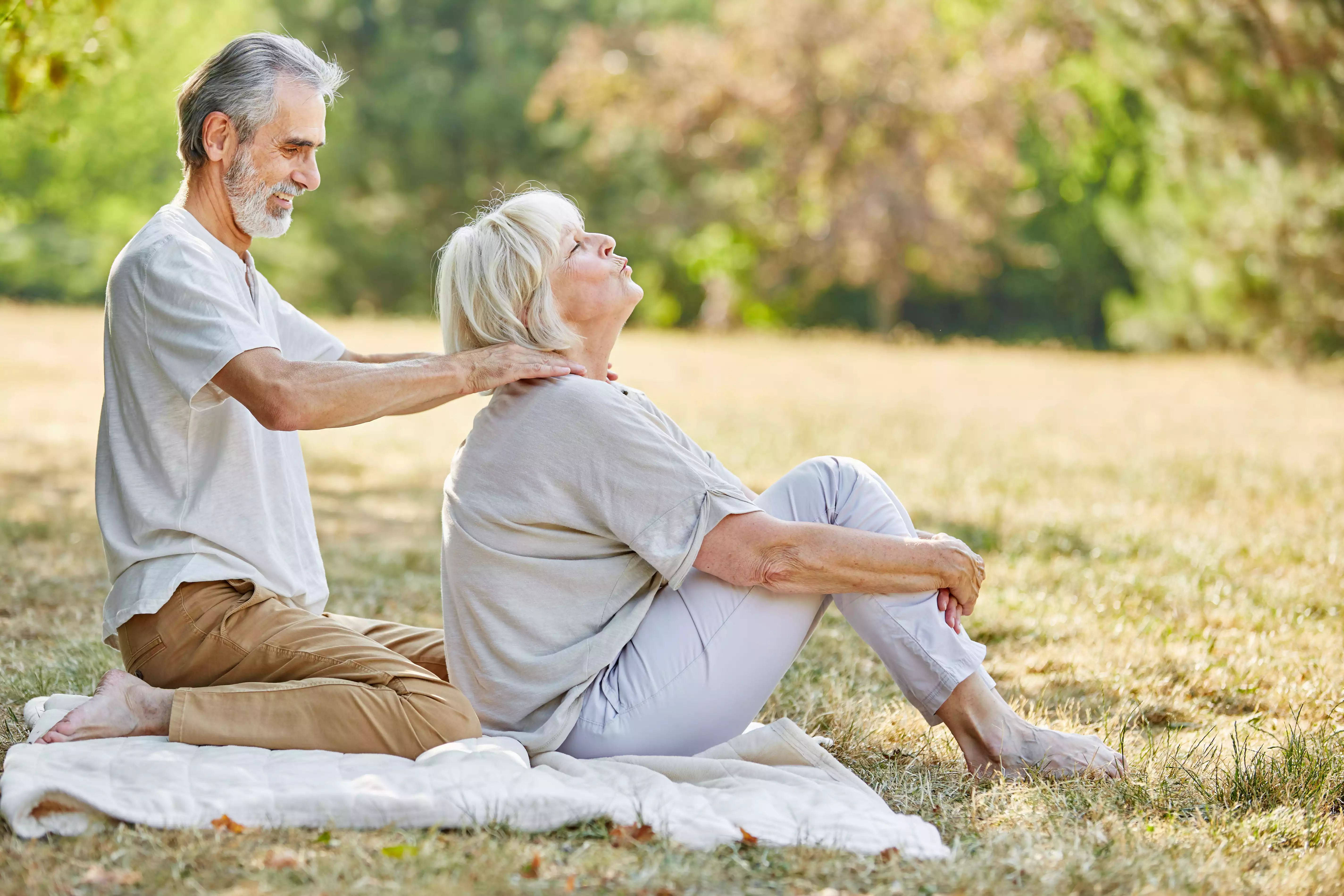 older couple relaxing massage on the grass